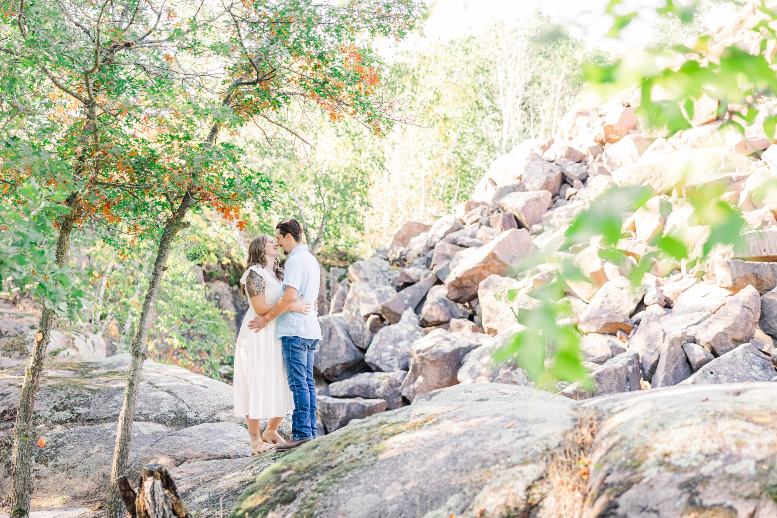 Happy couple laughing together during an autumn engagement session at Quarry Park, surrounded by vibrant fall colors.